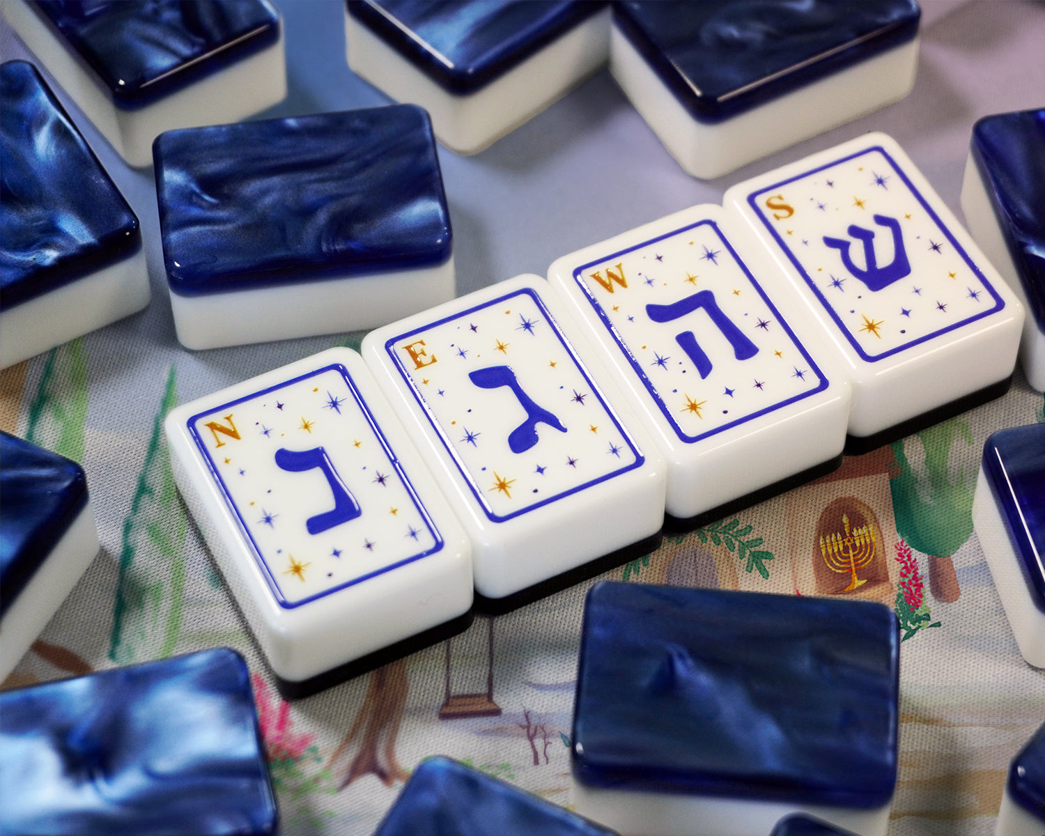 Close-up of Hebrew letter mahjong tiles on a colorful Hanukkah mahjong mat
