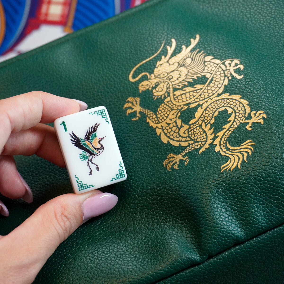 Legacy Emerald Edition crane tile beside the emerald tile bag with a gold dragon